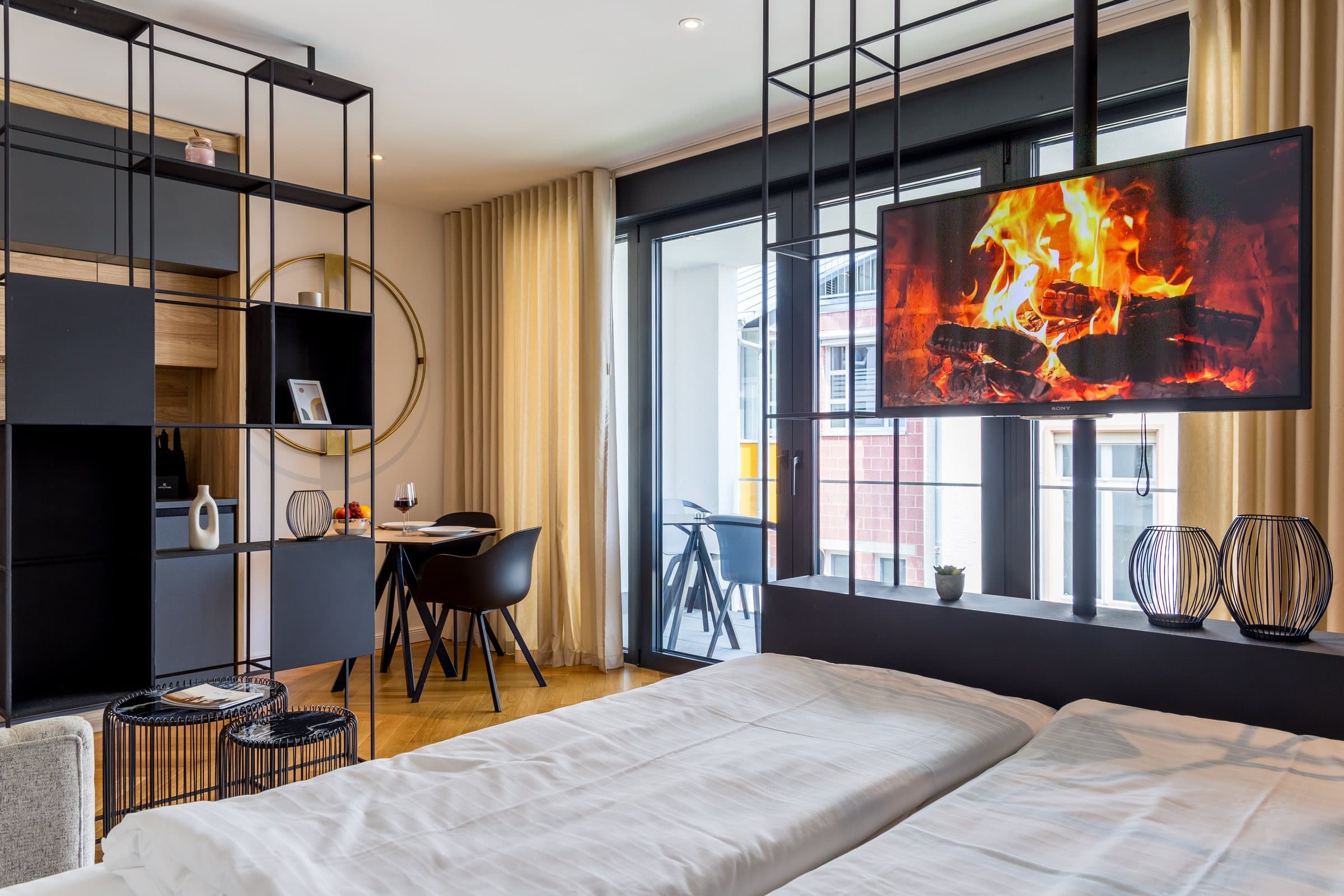 Schlaf- und Essbereich im Design Apartment Meißenheim von living TIMELESS mit Blick auf den Balkon